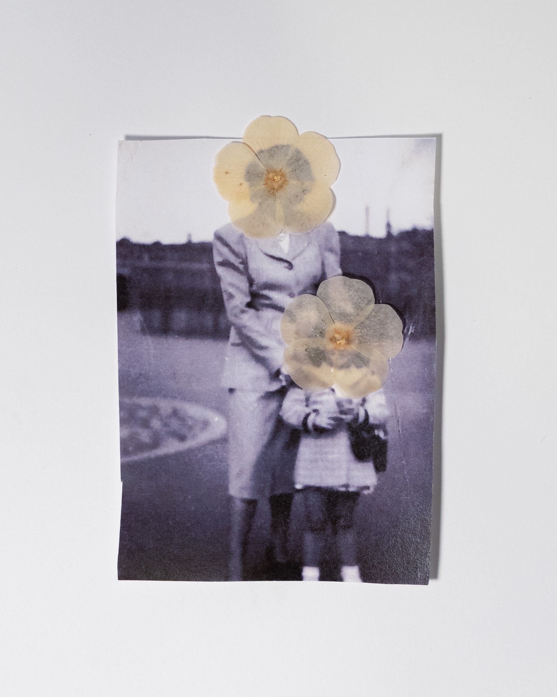 "Florence and Gloria Anonymous" by Emily Steinberger. The image depicts a photograph of mother and daughter with dried flowers covering the faces.